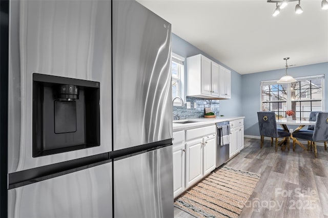 kitchen with stainless steel appliances, tasteful backsplash, sink, and white cabinets