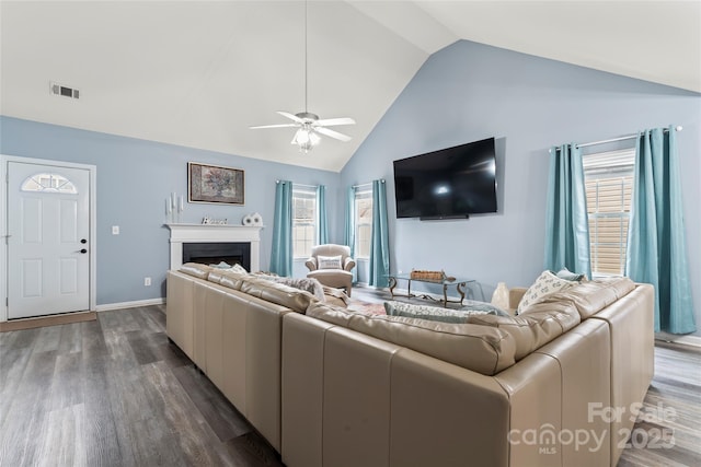 living room with dark wood-type flooring, ceiling fan, and high vaulted ceiling