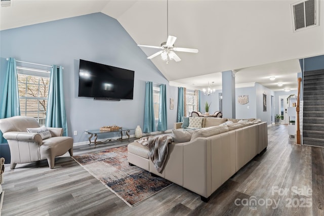 living room with wood-type flooring, ceiling fan with notable chandelier, and high vaulted ceiling