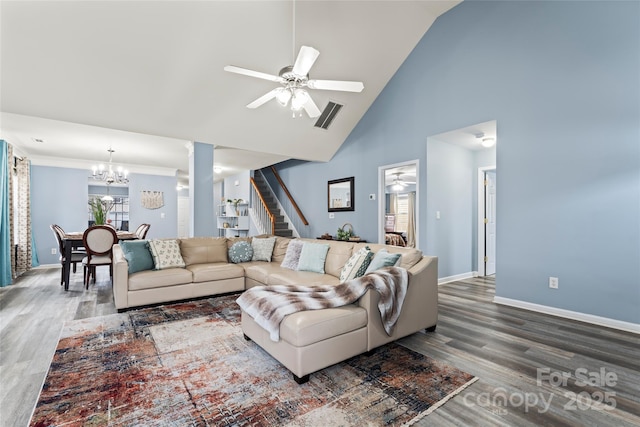 living room with hardwood / wood-style flooring, ceiling fan with notable chandelier, and high vaulted ceiling