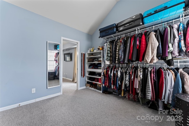 walk in closet with vaulted ceiling and carpet floors