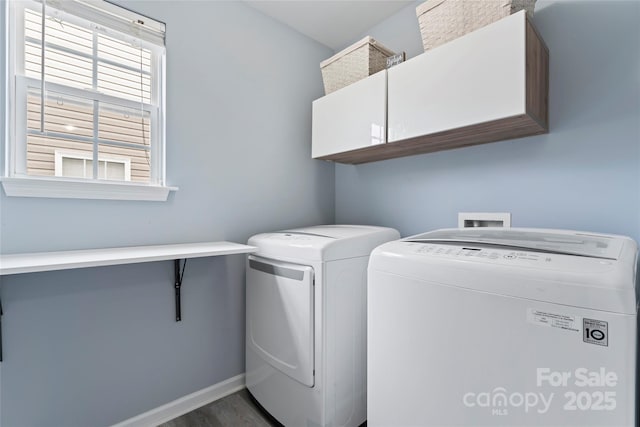 laundry room featuring cabinets, dark wood-type flooring, and washer and clothes dryer