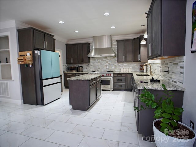 kitchen with pendant lighting, appliances with stainless steel finishes, wall chimney exhaust hood, tasteful backsplash, and a center island