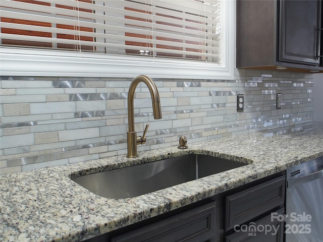 interior space featuring dishwasher, sink, dark brown cabinetry, backsplash, and light stone counters