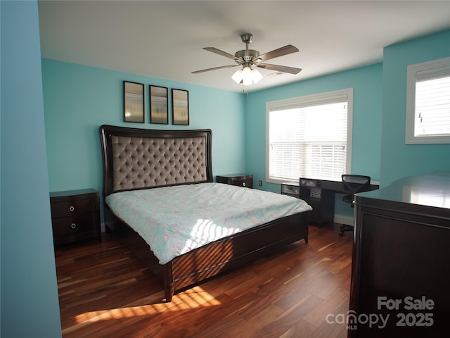 bedroom featuring ceiling fan, dark hardwood / wood-style floors, and multiple windows