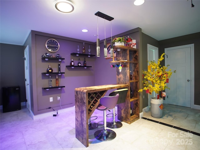 bar with pendant lighting and light tile patterned floors