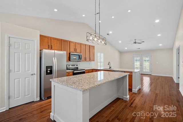 kitchen featuring sink, stainless steel appliances, a kitchen island, french doors, and kitchen peninsula