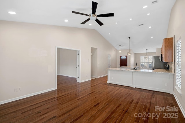 unfurnished living room featuring dark hardwood / wood-style flooring, sink, high vaulted ceiling, and ceiling fan