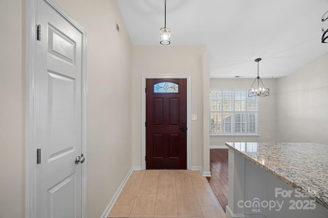 foyer entrance with a chandelier and light hardwood / wood-style flooring