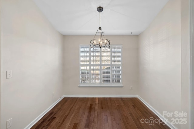 unfurnished dining area featuring dark hardwood / wood-style flooring and an inviting chandelier