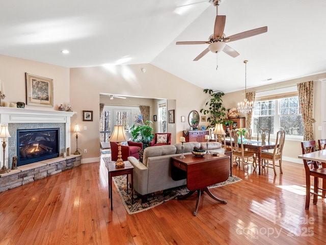 living room with ceiling fan, light hardwood / wood-style flooring, a fireplace, and lofted ceiling