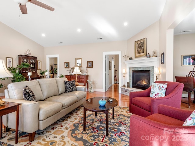 living room with ceiling fan, light hardwood / wood-style flooring, and vaulted ceiling