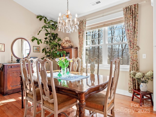 dining space featuring a chandelier and light hardwood / wood-style flooring