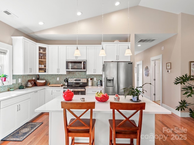 kitchen featuring sink, a center island, hanging light fixtures, and appliances with stainless steel finishes