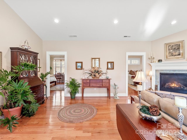 living room with a fireplace and light wood-type flooring