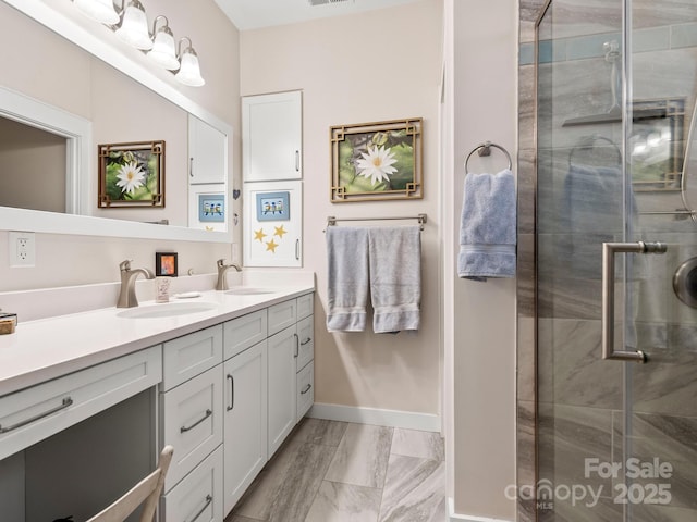 bathroom featuring a shower with shower door and vanity