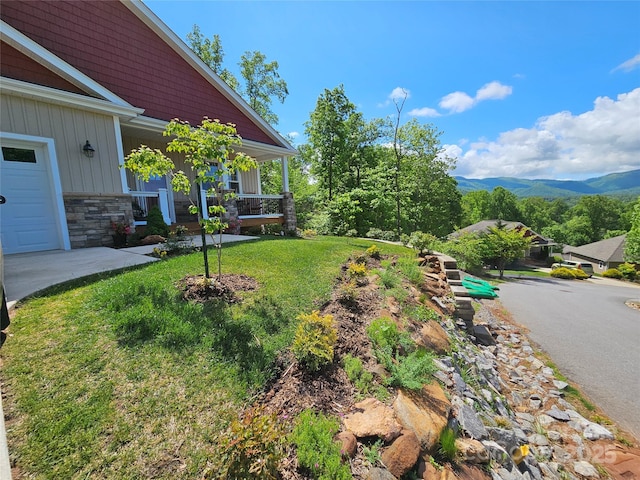 view of yard with a mountain view and covered porch