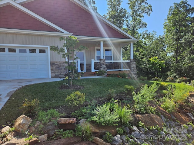 craftsman-style house with a front yard, a porch, and a garage