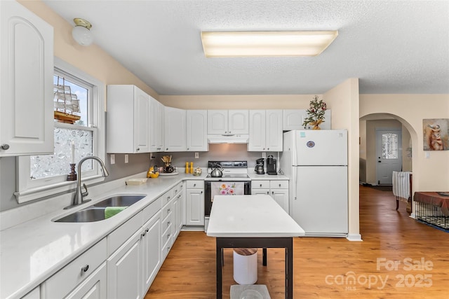 kitchen with white refrigerator, sink, and white cabinets