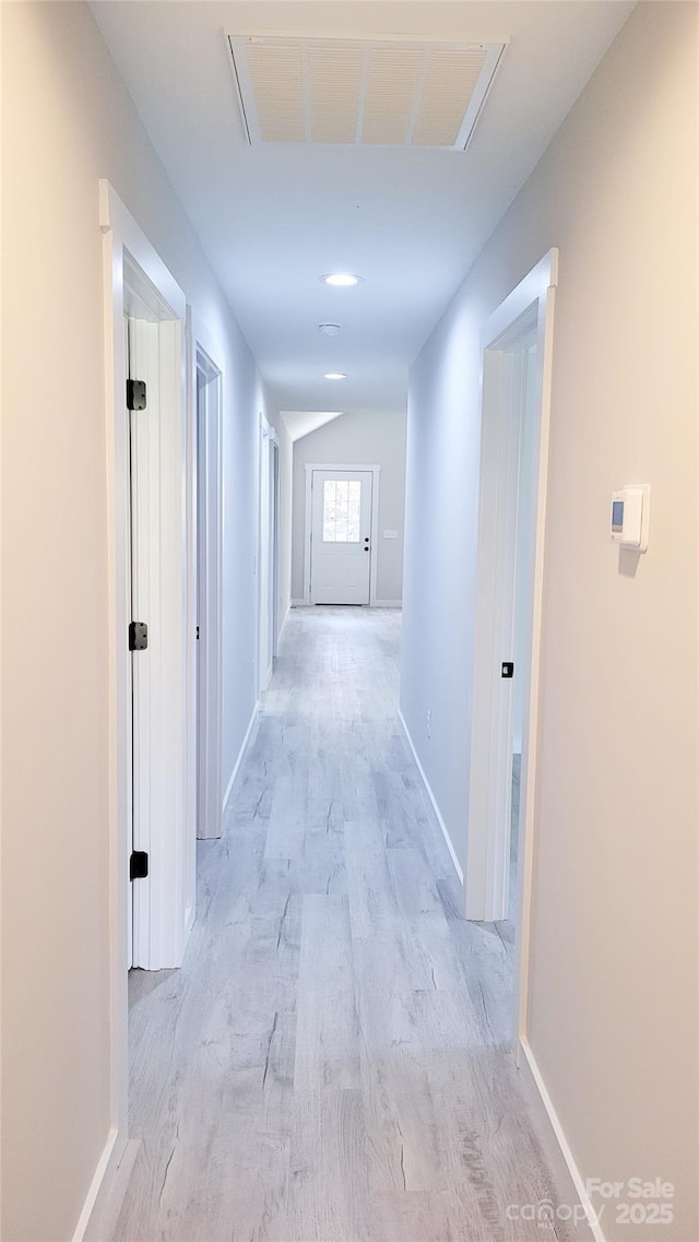 corridor featuring visible vents, vaulted ceiling, and baseboards