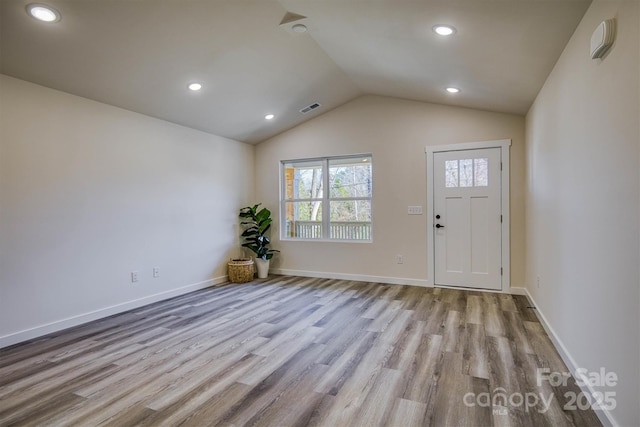 foyer featuring baseboards, visible vents, lofted ceiling, wood finished floors, and recessed lighting