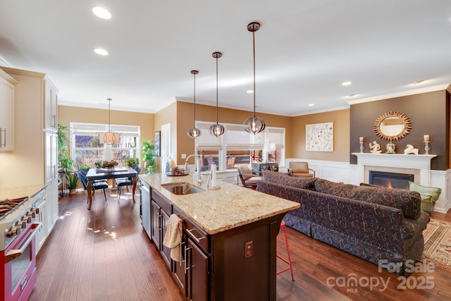 kitchen featuring dark brown cabinetry, pendant lighting, a breakfast bar, and appliances with stainless steel finishes