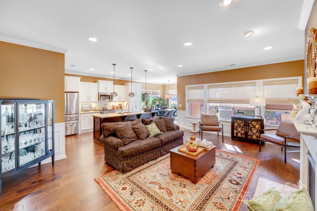 living room featuring ornamental molding, dark hardwood / wood-style floors, and sink