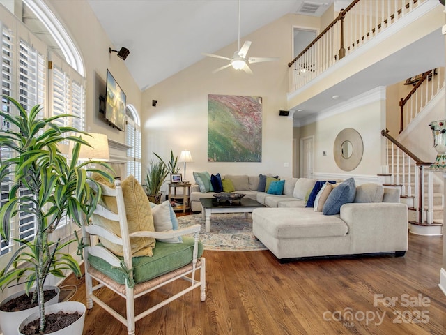 living room with hardwood / wood-style floors, high vaulted ceiling, and ceiling fan