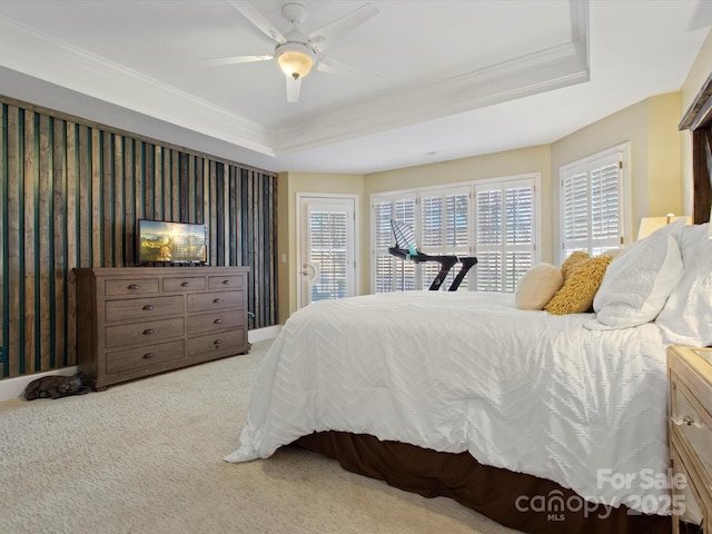 bedroom with carpet floors, a tray ceiling, ceiling fan, and ornamental molding