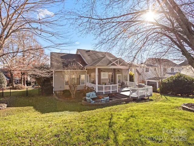 rear view of house featuring a wooden deck and a yard