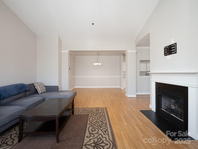 living room featuring ornamental molding, hardwood / wood-style floors, and a chandelier