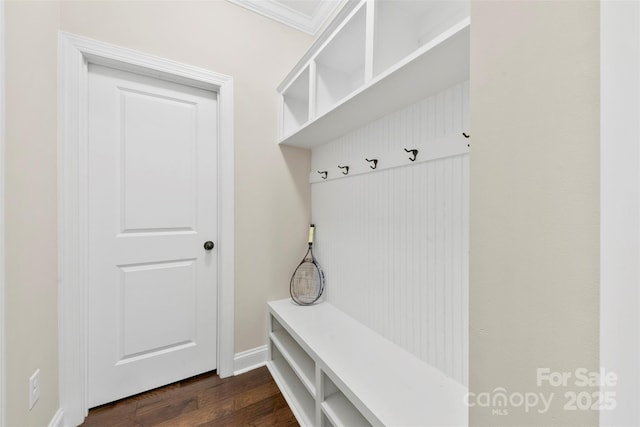 mudroom featuring crown molding, dark wood-style flooring, and baseboards