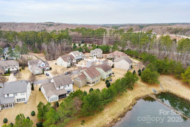 drone / aerial view featuring a residential view and a wooded view