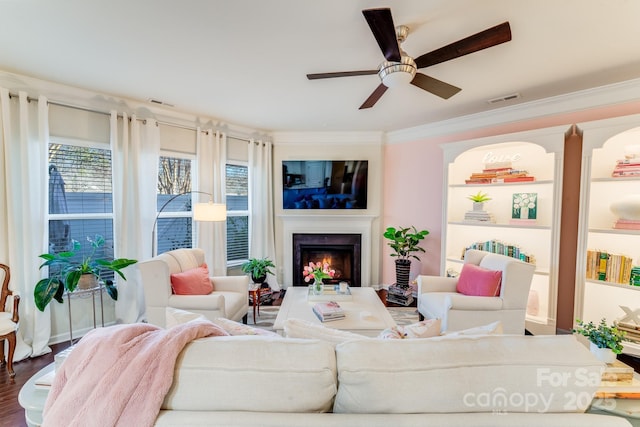 living room with ceiling fan, wood-type flooring, and ornamental molding