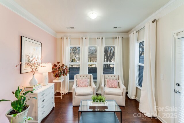 sitting room featuring dark hardwood / wood-style flooring, crown molding, and a healthy amount of sunlight