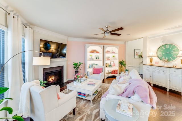 living room featuring crown molding, hardwood / wood-style flooring, and ceiling fan