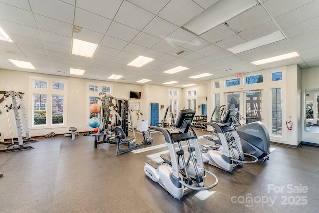 gym featuring french doors and a paneled ceiling