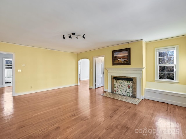 unfurnished living room featuring rail lighting and light wood-type flooring