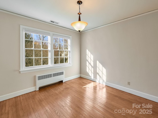 unfurnished dining area featuring light hardwood / wood-style flooring and radiator heating unit