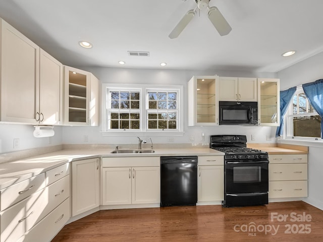 kitchen with sink, ceiling fan, dark hardwood / wood-style floors, black appliances, and white cabinets