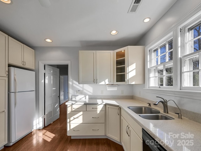 kitchen with light stone counters, sink, white fridge, and white cabinets