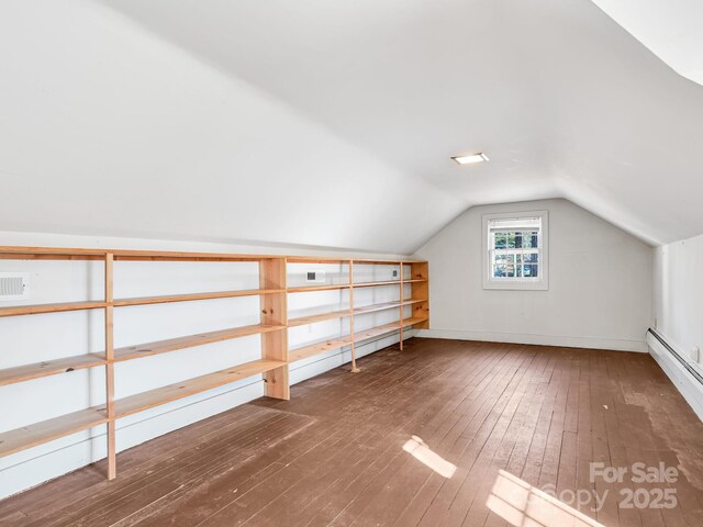 additional living space with lofted ceiling, dark wood-type flooring, and a baseboard radiator