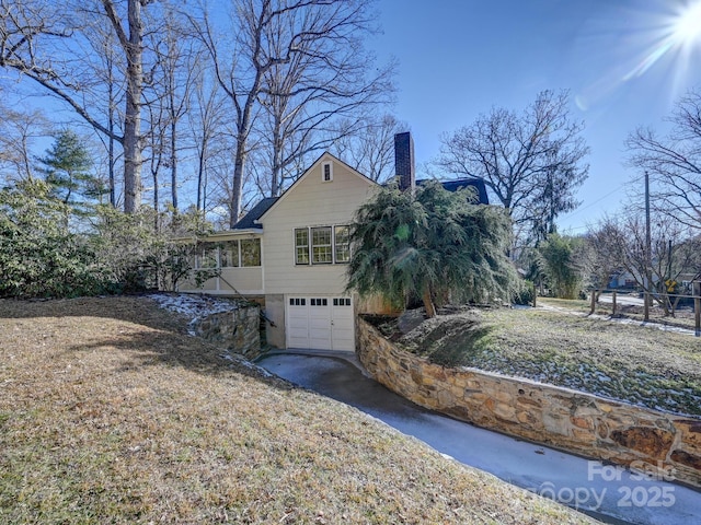 view of side of home featuring a garage and a yard