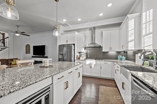 kitchen featuring decorative light fixtures, white cabinetry, wall chimney exhaust hood, and stainless steel appliances