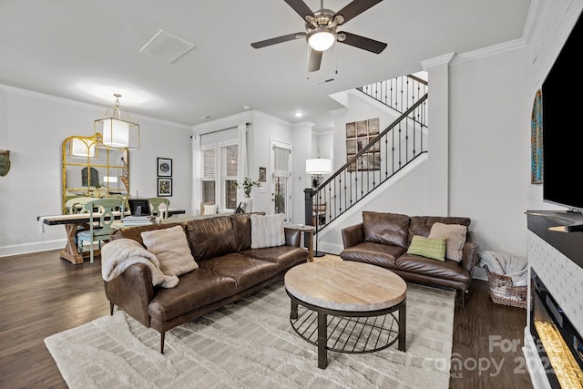 living room featuring a fireplace, ceiling fan, dark hardwood / wood-style flooring, and ornamental molding