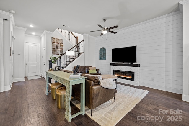 living room featuring ceiling fan, dark wood-type flooring, and crown molding