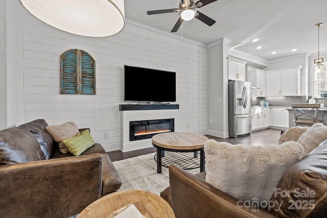 living room featuring ceiling fan, dark hardwood / wood-style flooring, and ornamental molding