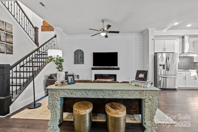 living room with ceiling fan, dark hardwood / wood-style flooring, and crown molding