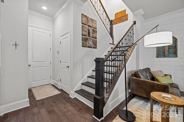 entrance foyer with wood walls, ornamental molding, and dark hardwood / wood-style floors