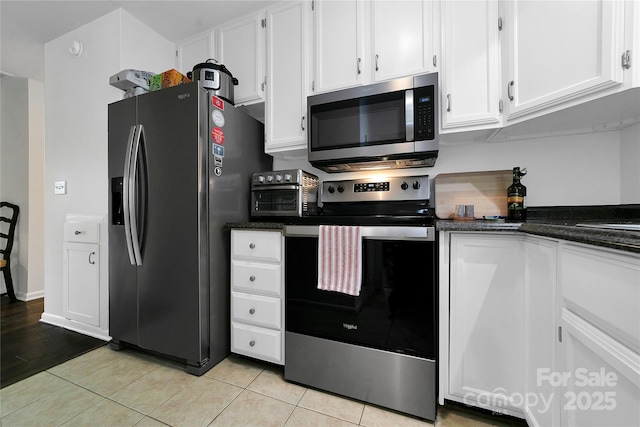 kitchen with white cabinetry, appliances with stainless steel finishes, and light tile patterned flooring